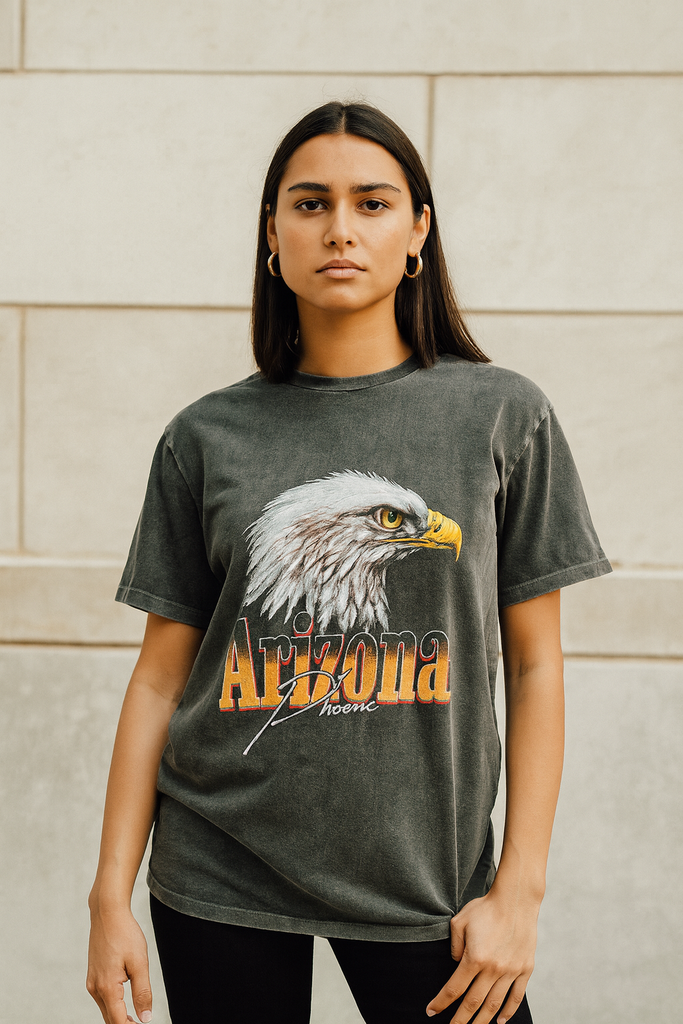 Person wearing a t-shirt with an eagle graphic and 'Arizona Forever' text against a beige wall.
